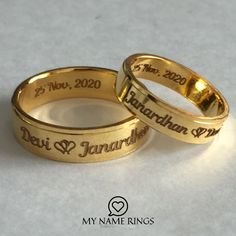 two gold wedding rings with names engraved on them