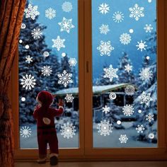 a little boy looking out the window at snowflakes on the outside and inside