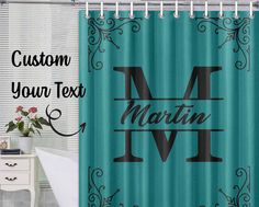 a shower curtain with the letter m in black and teal blue, next to a bathtub