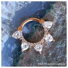 a close up of a gold ring with diamonds on it's side and water in the background