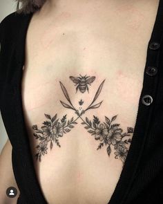 a woman's chest with flowers and a bee tattoo on her left side ribcage