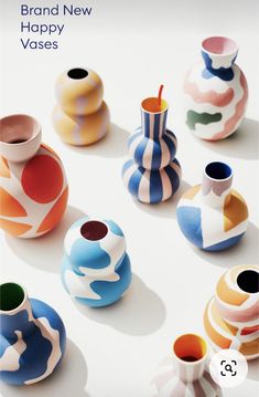 there are many colorful vases on the table