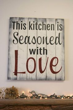 this kitchen is seasoned with love sign on a mantel in front of christmas lights