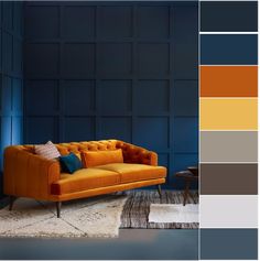 an orange couch with blue walls and rugs in the corner, next to a coffee table