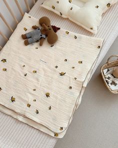 a baby crib with a teddy bear and other items on top of the bed