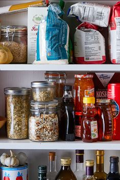 shelves filled with different types of food and condiments, including nuts, spices, and other foodstuffs