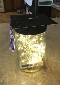 a graduation cap on top of a jar filled with lights