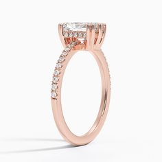 a rose gold engagement ring with an oval shaped center stone surrounded by small round diamonds