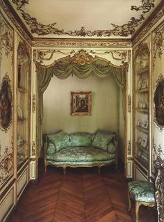 an ornately decorated room with a couch and bookshelf in front of it