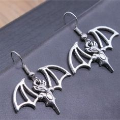 Elevate Your Goth Aesthetic Or Halloween Vampire Costume To New Heights Of Spook-Tacular Style With Our Bat Earrings! These Earrings Are More Than Just Accessories; They're Your Ticket To Becoming The Night's Most Enchanting Creature. These Bewitching Bats Dangle From Your Ears, Casting An Aura Of Mystery And Allure. Whether You're Fluttering Around A Costume Party Or Embracing Your Inner Creature Of The Night, These Earrings Will Have You Feeling Like The Ultimate Gothic Fashionista. Get Ready Halloween Fantasy Earrings For Pierced Ears, Fantasy Halloween Earrings For Pierced Ears, Fantasy Metal Earrings For Halloween, Gothic Earrings For Costume Party, Halloween Cosplay Earrings, Vampire Style Metal Earrings For Halloween, Halloween Vampire Metal Earrings, Silver Fantasy Earrings For Halloween, Silver Metal Earrings For Cosplay