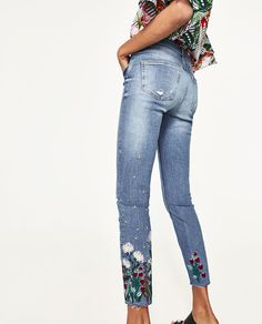 a woman in high rise jeans with flowers on the side