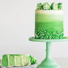 a green cake with white frosting and sprinkles sitting on a plate