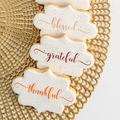 three decorated cookies sitting on top of a doily with the words grateful and grateful written on them