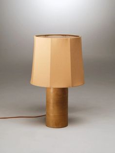 a table lamp with a brown shade on it's side and a white background