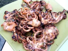 an octopus dish is served on a green plate