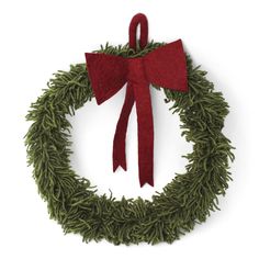 a green wreath with a red bow hanging from it's side on a white background