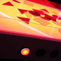 an electronic device with red and yellow lights on it's display case, in the dark