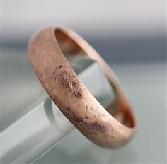 a close up of a wedding ring on a glass table with the reflection of it's surface