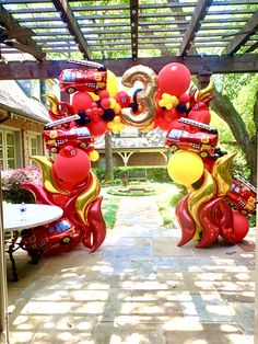 an archway decorated with red and yellow balloons