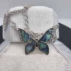 Dive into the mesmerizing beauty of the ocean and the sky with our Abalone Shell Blue Butterfly Necklace, a masterpiece forged in 925 Sterling Silver. Each flutter of the butterfly's wings reveals the ethereal dance of abalone shell's oceanic blues, accented with glimmers of crystal that catch the light like morning dew on a cobweb. The butterfly, an emblem of transformation and the promise of new beginnings, is poised in eternal grace, wings unfurled in a display of nature's unparalleled design Blue Butterfly Necklace, Mesmerizing Beauty, Butterfly Necklace, Sparkling Crystal, Abalone Shell, Blue Butterfly, Butterfly Wings, Sterling Silver Chains, Crystal Necklace