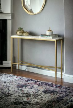 a table with a mirror on it next to a rug and a fire place in the corner