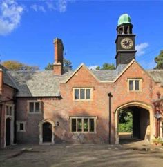 an old brick building with a clock tower in the middle of it's entrance