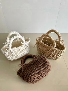 three baskets sitting on top of a table next to each other, one in brown and one in white