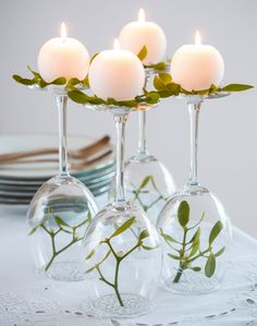 there are four wine glasses with candles in them