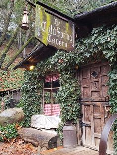 an old building covered in ivy with a sign that says the old spring tavern on it