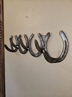 three horseshoes mounted to the wall with hooks