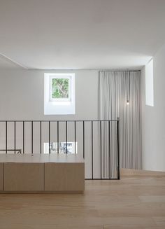 an empty room with wooden floors and white walls, has a window on the far wall