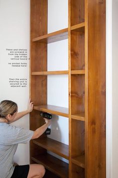 a woman is working on a book shelf