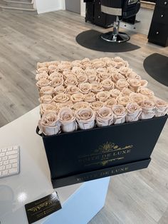 a large black box filled with roses on top of a white table next to a keyboard