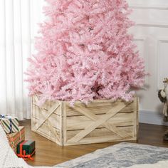 a pink christmas tree in a wooden crate