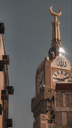 a large clock tower with a crescent moon on it's top and two buildings in the background