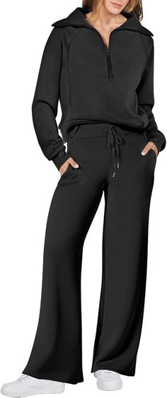 a woman in black pants and hoodie posing for the camera with her hands on her hips