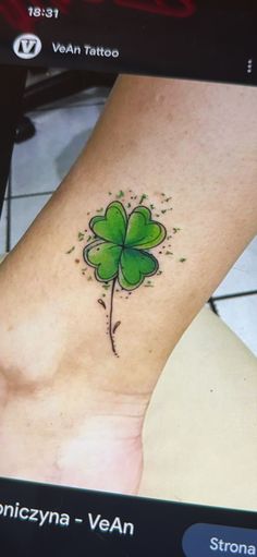 a green four leaf clover tattoo on the ankle