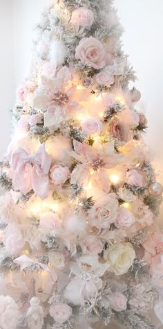 a white christmas tree decorated with pink flowers