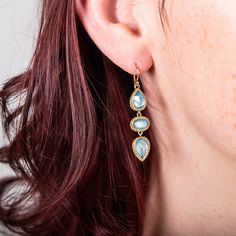 Three one-of-a-kind Aquamarine gemstones make up these trio earrings, reminiscent of cool, crystalline waters. Each stone has been set in a handmade 18k gold bezel with braided detail. Technical Details Metal: 18k yellow goldAquamarine: 5.07 cts.Total Length: 41mmEarewire: 18k french hookHandmade in New YorkStyle # E-2394-AQ Three-stone Aquamarine Jewelry For Gift, Three Stone Aquamarine Jewelry As A Gift, Three Stone Aquamarine Jewelry For Gift, Yellow Gold Three-stone Earrings For Gift, Three Stone Yellow Gold Earrings For Gifts, Gold Three-stone Earrings For Gift, Gold Aquamarine Jewelry With Gemstone Accents, Gold Aquamarine Gemstone Earrings, Gold Aquamarine Jewelry With Bezel Setting