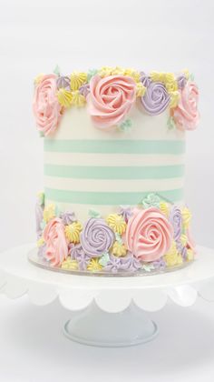 a multi - colored striped cake with flowers on top