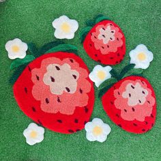 three strawberry rugs on the ground with flowers