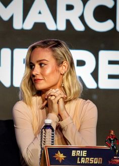 a woman sitting at a table in front of a microphone