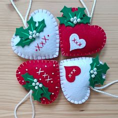 four felt christmas ornaments hanging from strings on a table