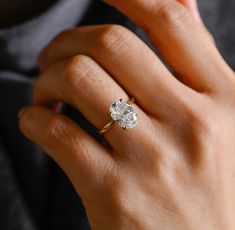 a woman's hand with a diamond ring on it