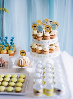 a table topped with lots of cupcakes and cakes