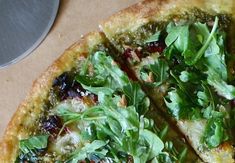 a close up of a pizza with greens on it