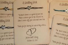 four wedding wish cards with hearts attached to the strings and two heart - shaped charms on them