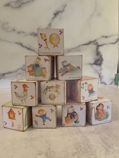 a stack of wooden blocks sitting on top of a marble counter covered in cartoon characters