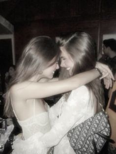 two young women hugging each other at a party