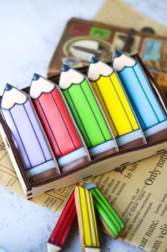 colorful crayons are lined up in a row on top of an old book